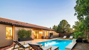A backyard with a swimming pool, lounge chairs, and a patio area. - NEW! Serenity & Style in Sedona - Pool, Red Rock Views, & more! (Sedona)
