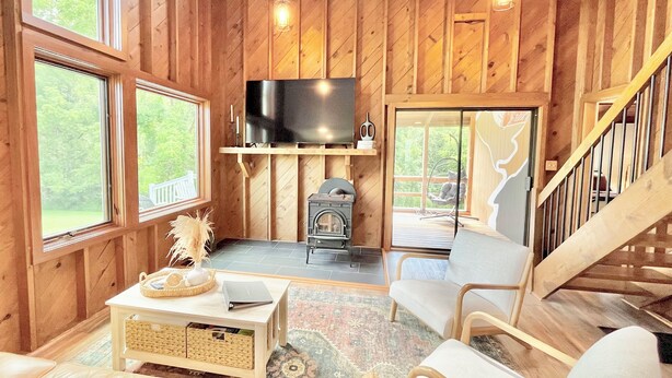 Un interior de madera acogedor con chimenea, televisor y un espacio de estar cómodo.
