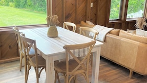 Un interior de madera con una mesa de comedor, sillas y un sofá.