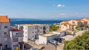 Un quartier résidentiel situé sur la côte, avec des immeubles modernes, une vue dégagée sur la mer et un espace de stationnement.