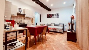 Un espace de vie compact comprenant une cuisine, un coin repas et un lit.