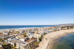 A coastal town with buildings along the beach and a view of the ocean. - Waterfront Condo | Fireworks View | Kid Friendly | Swimmable Beach (San Diego)