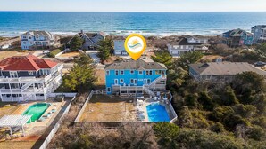 A coastal residential area with multiple houses, a swimming pool, and a pier. - Fore Decs: Private Pool, Tiki Bar & Ocean Views (Corolla)