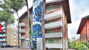 A multi-story building with balconies, a blue glass facade, and a brick exterior.