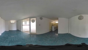 A panoramic view of a room with a curved ceiling, a washing machine, and a door leading to another room. - Holiday apartment mit Klimaanlage und Balkon (Lignano Sabbiadoro)