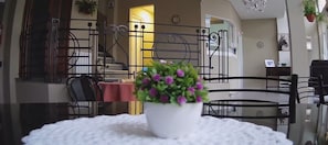 A dining area with a round table, chairs, and a potted plant.