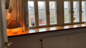 A room with a windowed bench, a lamp, and a radiator. - Ferienwohnung Apfelrose - Urlaub im Malerischen Inseldorf Oldsum (Oldsum)
