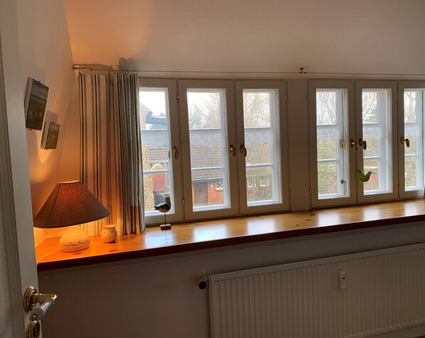 A room with a windowed bench, a lamp, and a radiator.