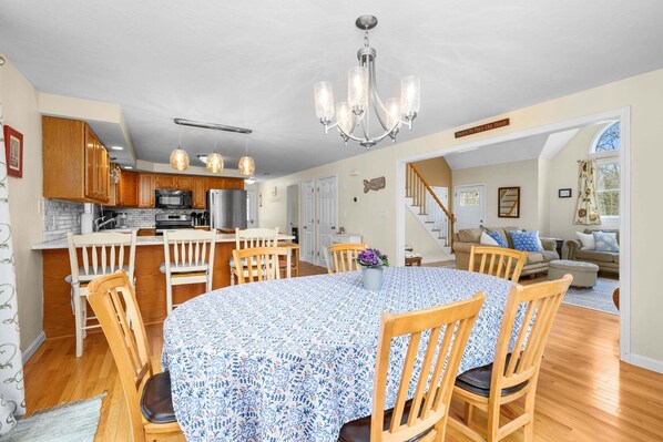 Une cuisine spacieuse avec des meubles en bois, un îlot central et un lustre.