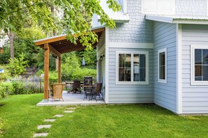 A house with a covered patio, a lawn, and a stone pathway. - Shared Boat Dock, Waterfront Property, New build 2023 (Bigfork)