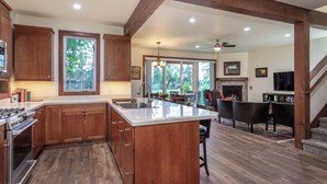 Una cocina amplia con armarios de madera, una isla grande y un comedor con chimenea.