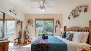 A bedroom with a large bed, a ceiling fan, and a view of the outdoors. - Relax in luxury at Sedona Desert Poppy, a 3-bed oasis in beautiful West Sedona. (Sedona)