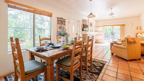 A dining area with a wooden table and chairs, a rug, and a view of the outdoors. - Relax in luxury at Sedona Desert Poppy, a 3-bed oasis in beautiful West Sedona. (Sedona)