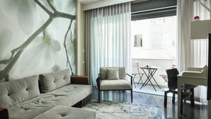 A modern living room with a grey sofa, a small armchair, a coffee table, and a TV. - White Blossom Dizengoff CTR by SeaN'Rent (Tel Aviv)
