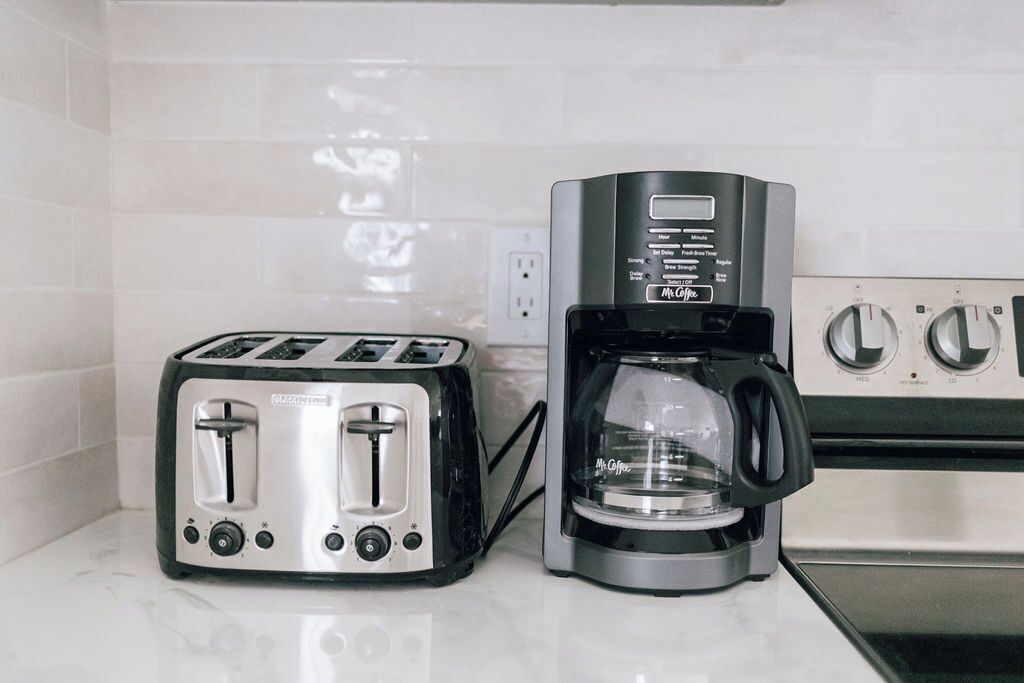 Una cocina con un tostador y una cafetera sobre la encimera.