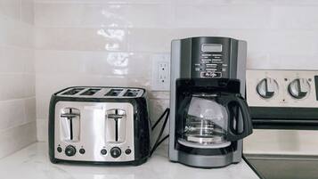 Una cocina con un tostador y una cafetera sobre la encimera.