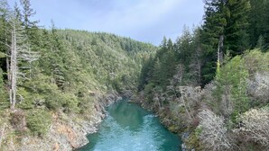 Un fiume che scorre attraverso una valle boscosa, con sponde rocciose e alberi fitti.