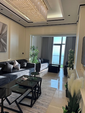A modern living room with a sofa, coffee table, and decorative plants.