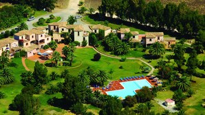 An aerial view of a resort with multiple villas, a swimming pool, and lush greenery. - Residence Baia delle Palme Unit 1-Studio (Santa Margherita di Pula)