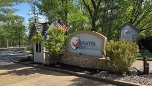 A sign for Regatta Bay with a stone base and a small building structure. - Beautiful View of Main Channel 2 Bed/2 Bath Condo w/ Pools, Pickleball & Tennis! (Village of Four Seasons)