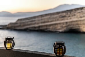 Two lanterns on a balcony overlooking a coastal landscape with cliffs. - Emmanouela Apartment Matala (Matala)