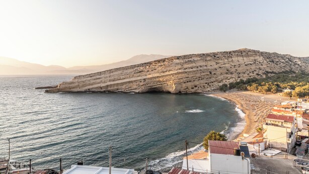 A coastal town with a beach, buildings, and a cliff. - Emmanouela Apartment Matala (Matala)