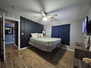 A bedroom with a bed, a ceiling fan, a TV, and a wooden floor. - Downtown Phoenix Triplex w/ Backyard & Free (Phoenix)