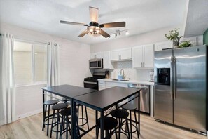 A modern kitchen with a central island, stainless steel appliances, and a ceiling fan. - Chic Scottsdale Apt 3 |FashionSquare|OldTown|4Plex (Scottsdale)