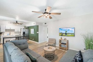 A modern living room with a sofa, a coffee table, and a television.
