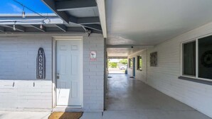 A building with a white exterior, a garage door, and a sign that reads 'LAUNDRY.'