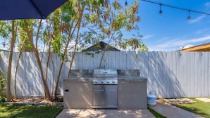An outdoor kitchen with a grill, a sink, and a barbecue area. - Chic Scottsdale Apt 2 |FashionSquare|OldTown|4Plex (Scottsdale)