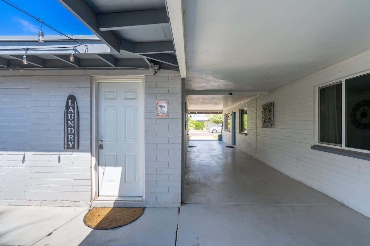 Een gebouw met een witte gevel, een garagepoort en een heldere lucht.