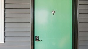 A green door with a numeric keypad lock and the number 18 on it. - Peninsula One unit 18 Close to downtown and beach (Traverse City)
