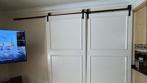 A room with a sliding door, a television, and a bar area. - Meridian by Strip 6ppl Amenities 2Qu&sofa kids ok (Las Vegas)