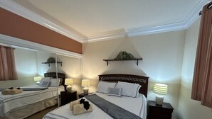 A hotel room with two beds, a large mirror, bedside lamps, and a plant on the headboard. - Meridian by Strip 6ppl Amenities 2Qu&sofa kids ok (Las Vegas)