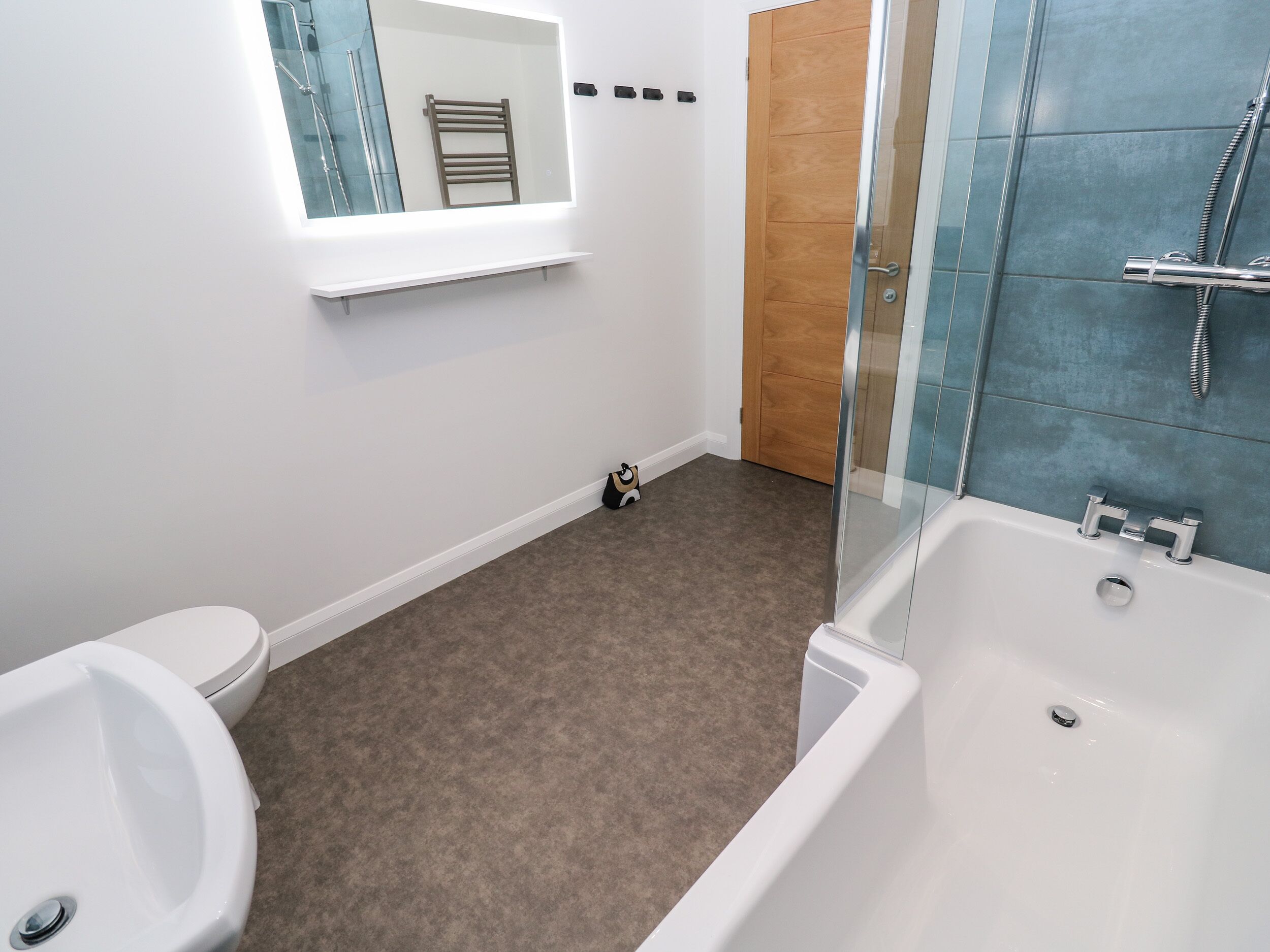 A modern bathroom with a toilet, sink, and bathtub.