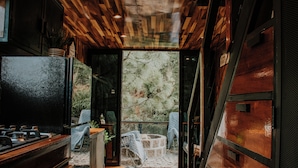 A modern kitchen with a large refrigerator, wooden cabinets, and a stone countertop. - K NAJ Community (Omitlán de Juárez)