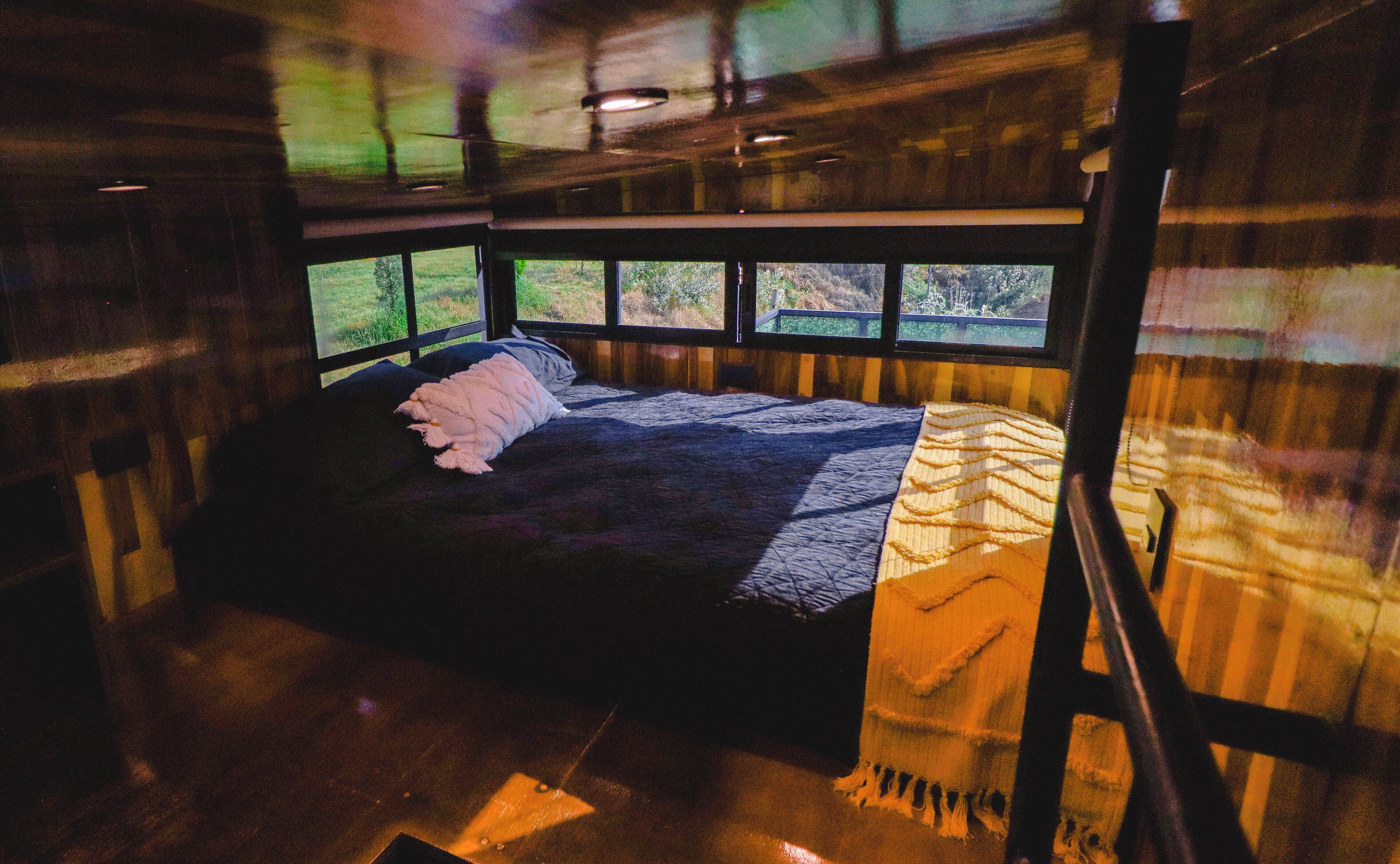A bedroom with a bed, a window, and a view of the outdoors.