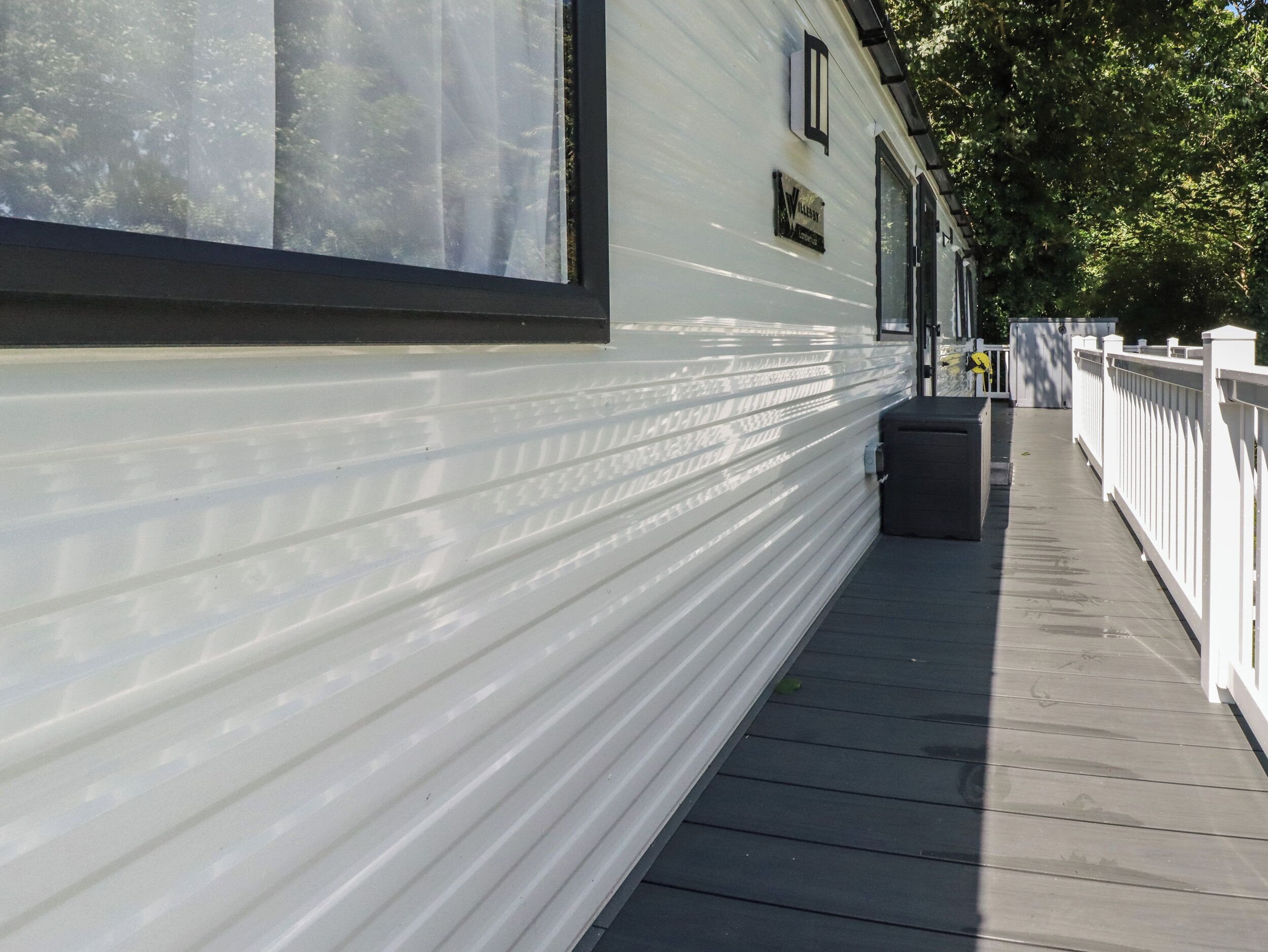 A white building with a covered walkway and a white fence.