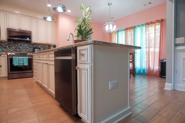 A kitchen with white cabinets, a stainless steel refrigerator, and a built-in oven.