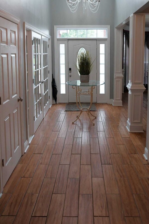 A hallway with wooden flooring, white doors, and a glass table with a plant. - The Relaxation Getaway
Sleeps 10 4 bedrooms 3.5 baths (Savannah)