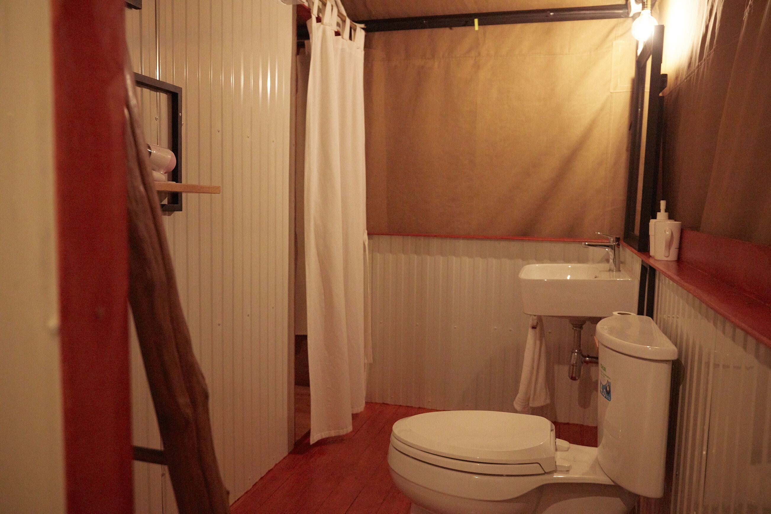 Ein kleines Badezimmer mit Toilette, Waschbecken und Duschvorhang.