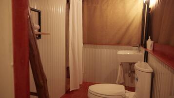 Ein kleines Badezimmer mit Toilette, Waschbecken und Duschvorhang.