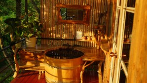 A rustic wooden cabin with a wooden deck, a large wooden barrel, and potted plants. - NUYU Khaoyai (Pak Chong)