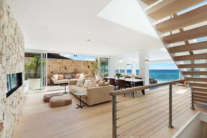 Enjoy ocean views from the spacious living area with a sofa, ottomans, and dining table.