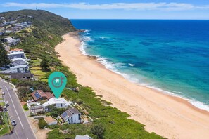 Overlooking the beach, this property offers stunning views of the ocean and lush surroundings.