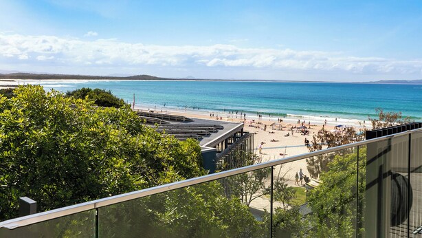 A beach view from a balcony with a clear sky, a sandy beach, and a calm sea. - 71 Hastings Street - Beachfront (Noosa Heads)