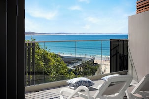A balcony with a clear view of the beach and ocean.
