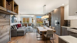 Una cocina moderna con comedor, estantes de madera y chimenea.