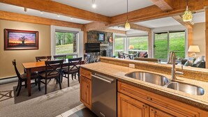 A kitchen with a granite countertop, stainless steel sink, wooden cabinets, and a dishwasher. - Enclave 102 | Snowmass Ski-In/Ski-Out Condo w/Shared Pool/Hot Tub (Snowmass Village)